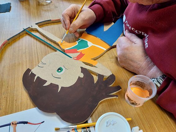 personne âgée en train de peindre un personnage